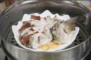 將鱸魚成花狀擺好，將火腿切片放入各縫隙中，放入鍋中隔水蒸12分鐘拿出，撒上蔥花即可。